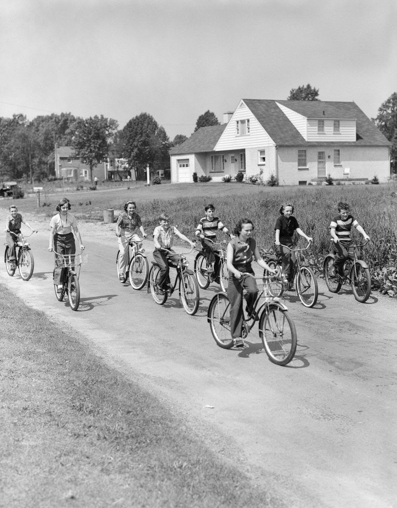 Detail of 1950s 8 Kids Boys and Girls Ride Bicycles On Country Rural Road Lane Fun House In Background by Anonymous