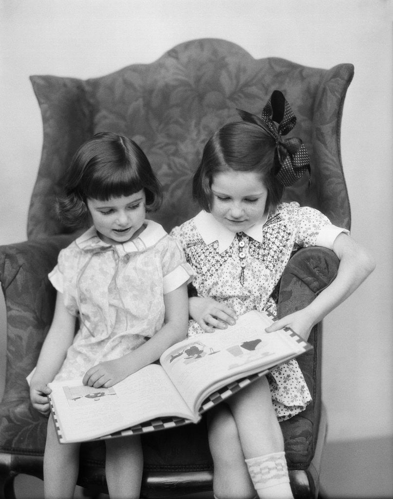 Detail of 1920s 1930s Two Girls Sitting Side By Side In Chair Reading Book by Anonymous