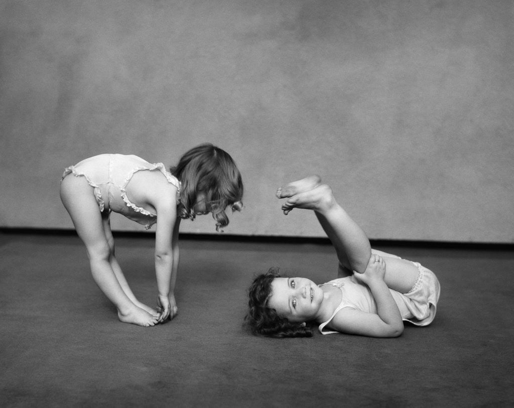 Detail of 1930s Two Girls Wearing Underclothes Playing At Exercising by Anonymous