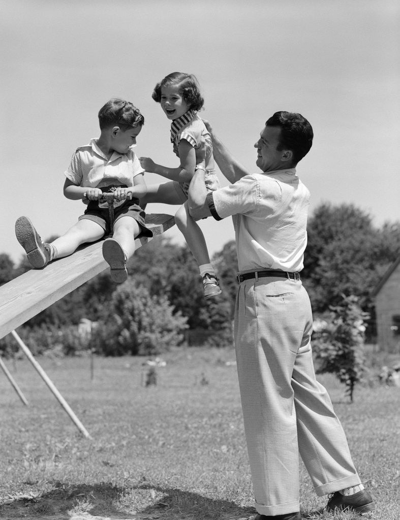 Detail of 1950s Father Lifting Son And Daughter Onto A Playground Seesaw Outdoor by Anonymous