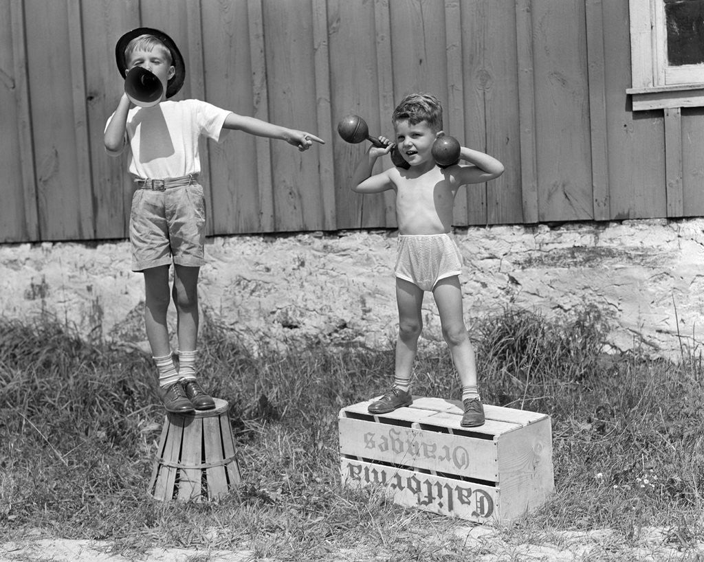 Detail of 1930s 1940s Boys Playing Carnival Strongman One Lifting Dumbbells Other Announcing Act Through Megaphone by Anonymous
