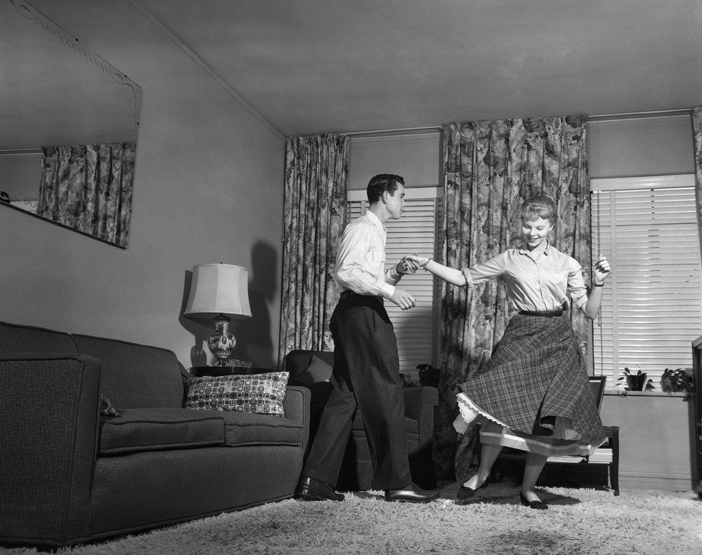 Detail of 1950s Teen Couple Doing Jitterbug Rock And Roll Dance In Living Room Man Woman Boy Girl by Corbis