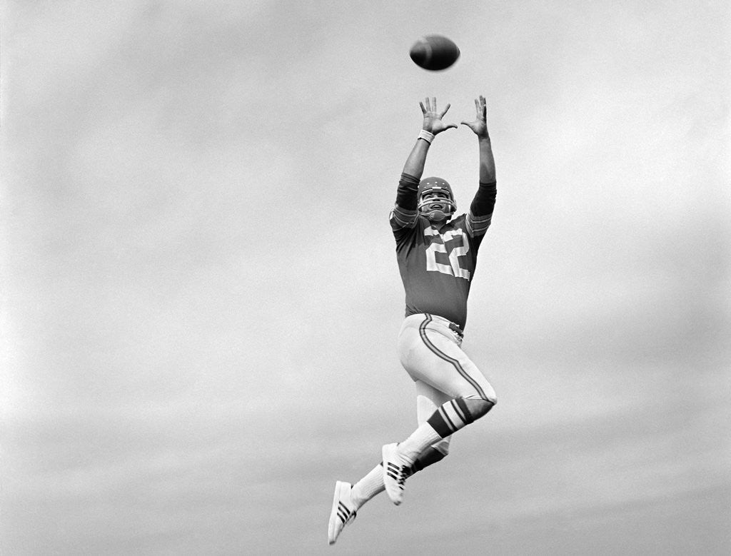 Detail of 1970s Player Jumping To Catch Football Pass by Anonymous