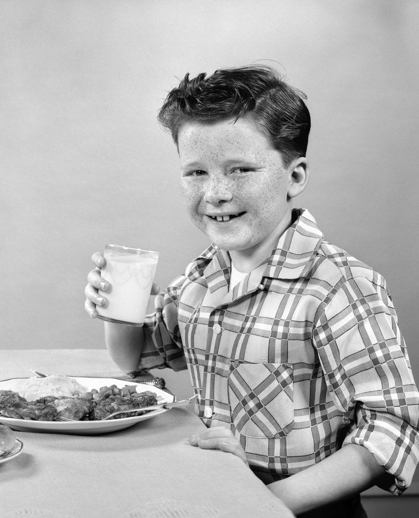 Detail of 1930s 1940s Freckle-Faced Boy Sitting Dinner Table Holding Glass Milk by Corbis