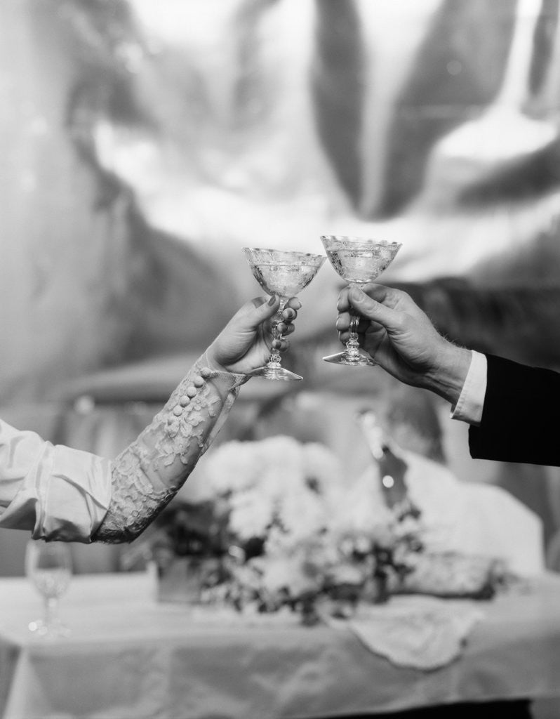 Detail of Hands and Arms Of A Bride And Groom Toasting With Champagne Glasses by Anonymous