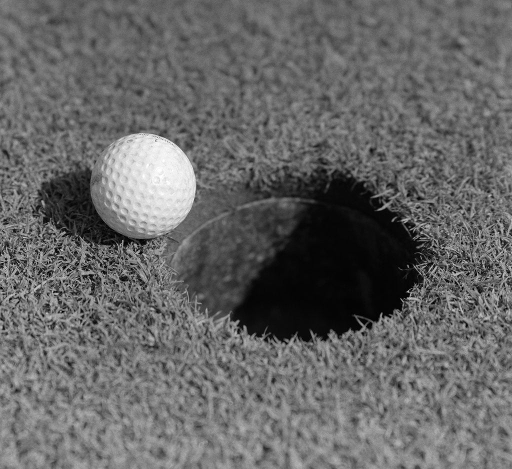 Detail of 1950s Close-Up Of Golf Ball On Green On Very Edge Of Cup by Corbis