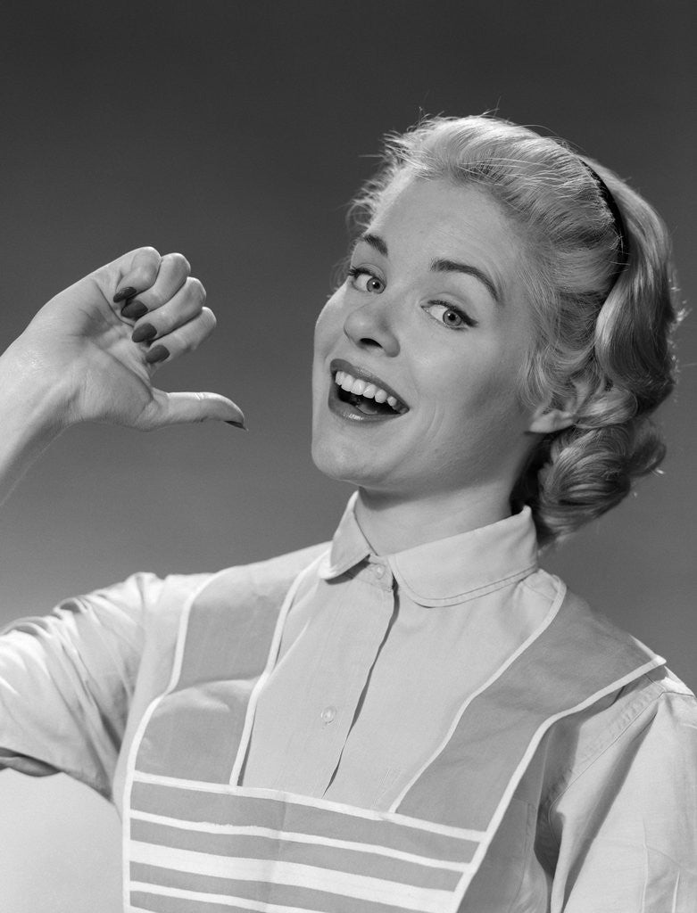 Detail of 1950s 1960s Woman Housewfe In Apron Proudly Pointing At Herself With Thumb by Anonymous