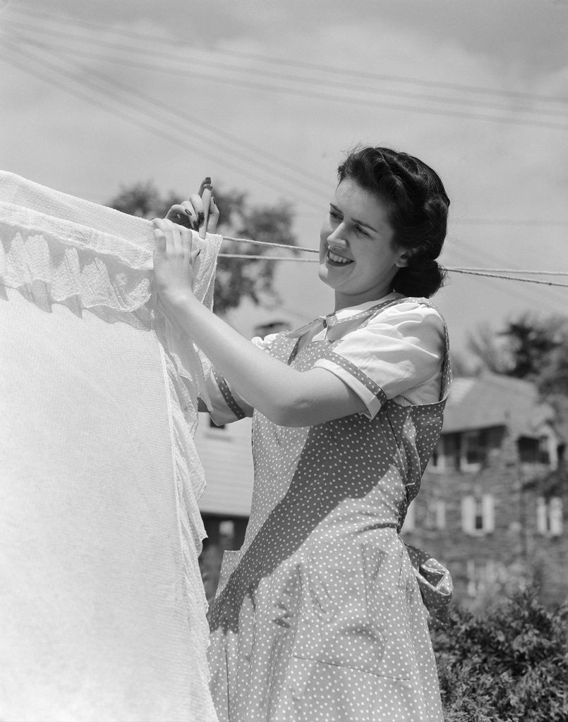 Detail of 1940s Woman Hanging Laundry On Clothesline Outdoors by Corbis