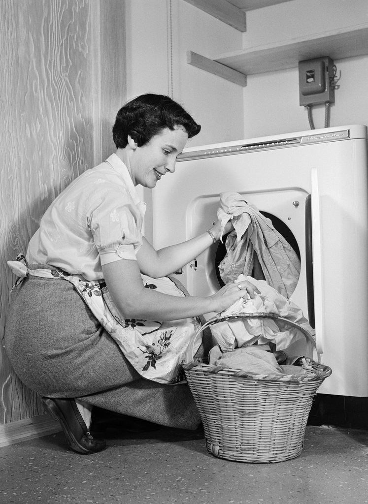 Detail of 1950s Woman Kneeling Removing Clothes Laundry From Automatic Dryer by Anonymous