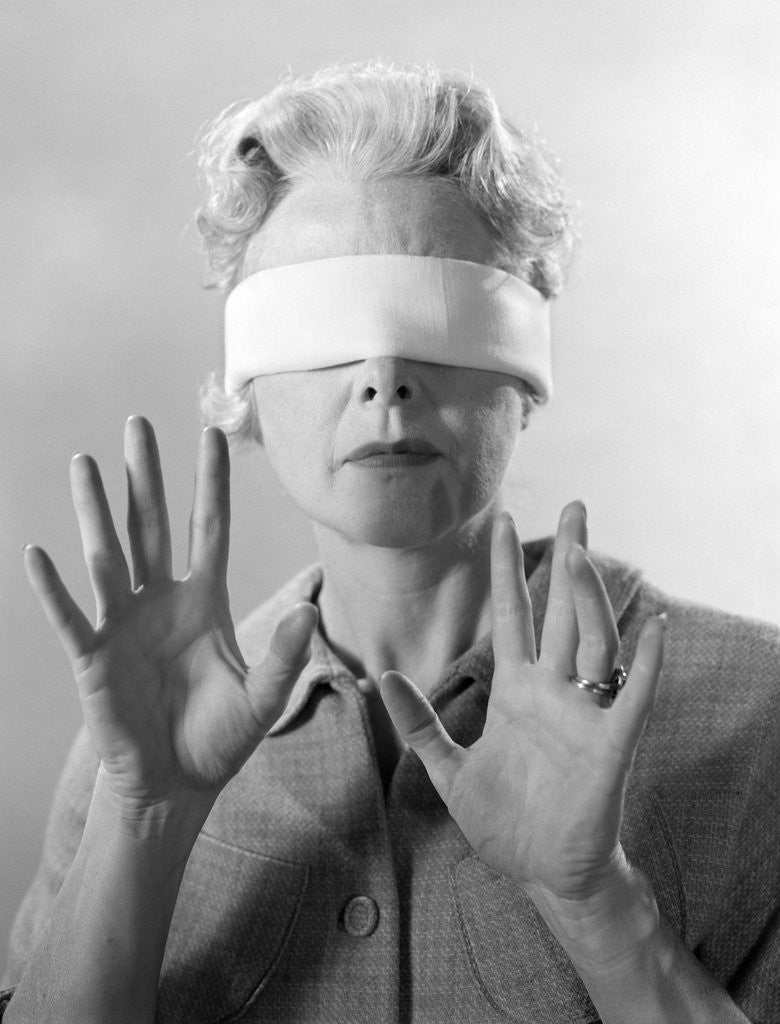 Detail of 1960s Elderly Woman Wearing Blindfold Holding Up Her Hands by Anonymous