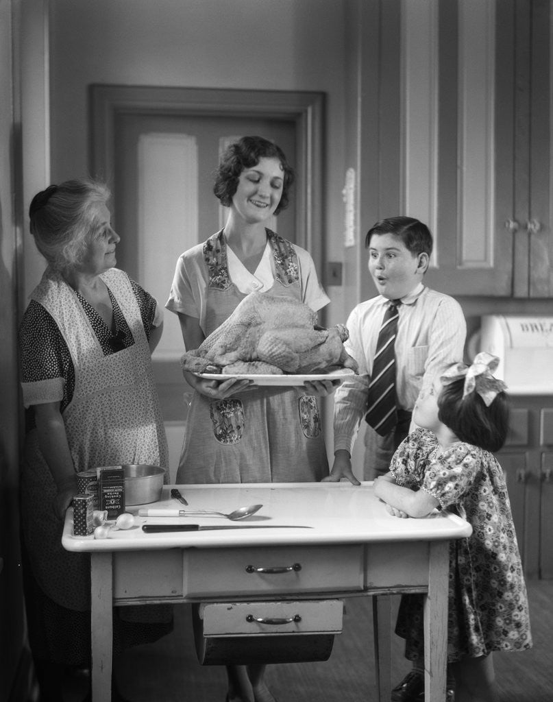 Detail of 1920s 1930s Mother Grandmother Boy Girl Cooking Turkey In Kitchen by Corbis