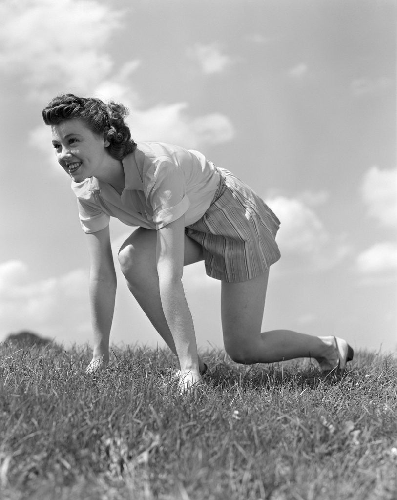 Detail of 1940s Young Teen Woman Kneeling In Grass In Track Race Ready Starting Position by Anonymous