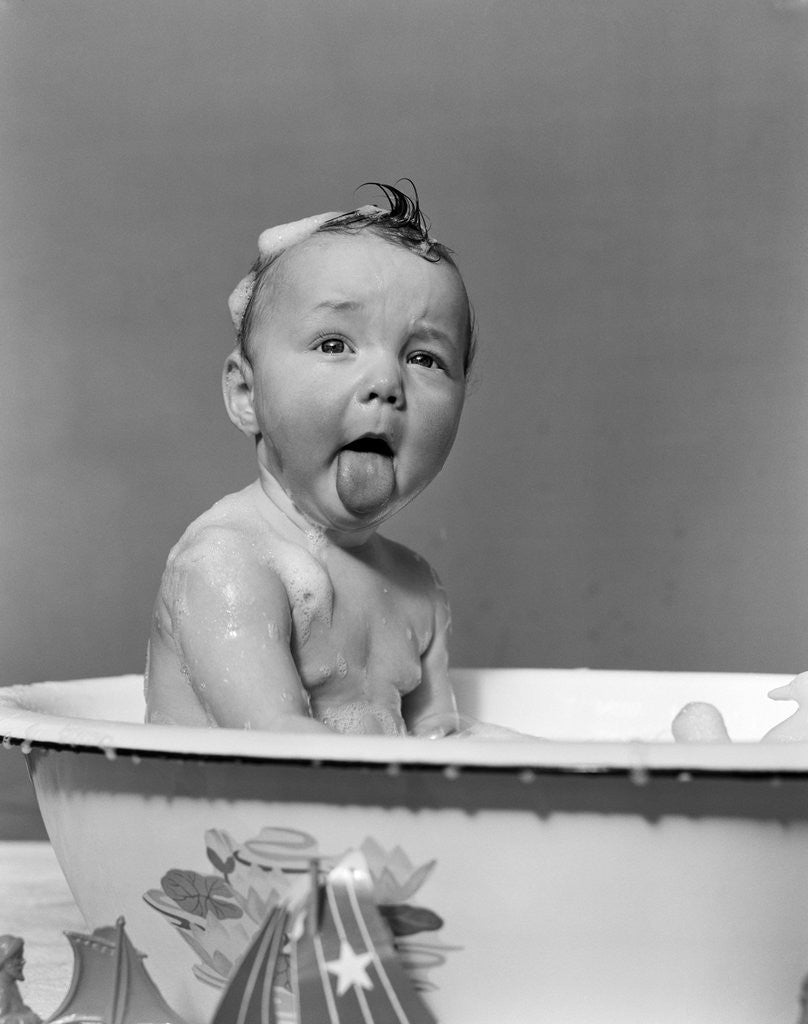 Detail of 1940s Wet Baby In Bath Covered With Soap Suds Sticking Out Tongue by Anonymous