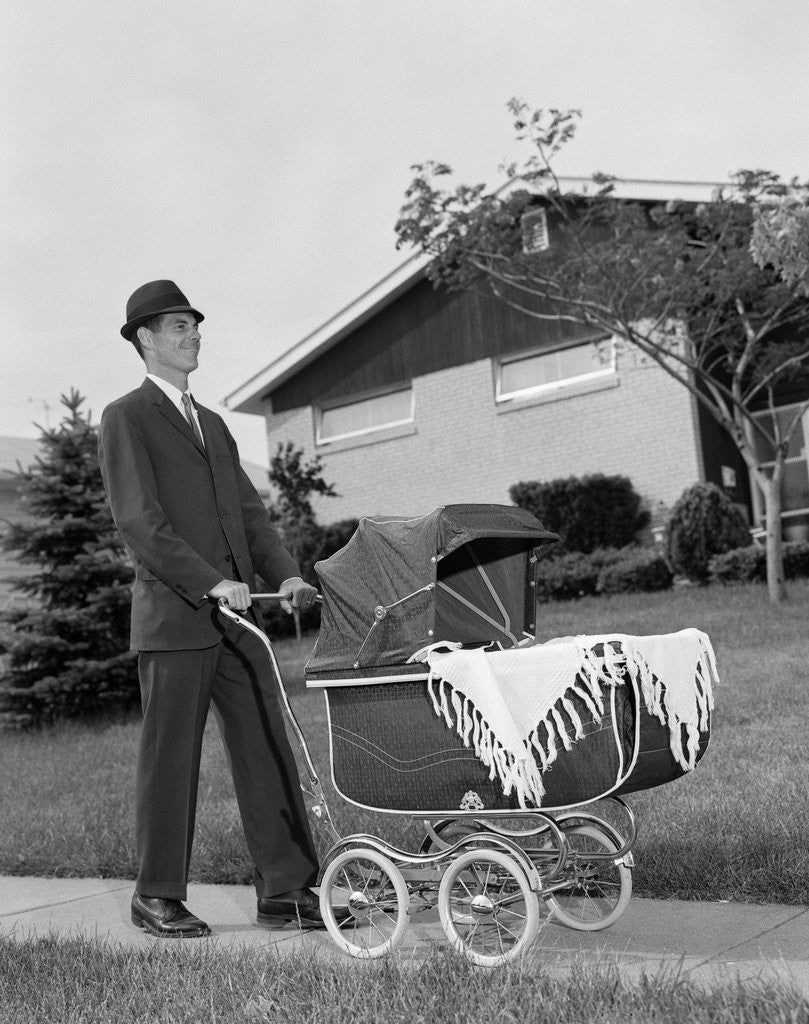 Detail of 1960s Man Pushing Stroller Baby Carriage Suburban Sidewalk by Corbis