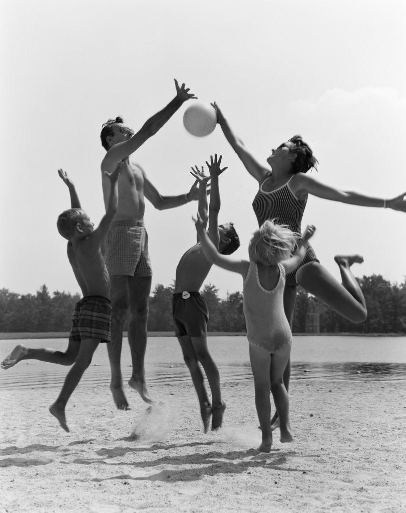 Detail of 1960s Family Jumping Playing Beach Volleyball by Corbis