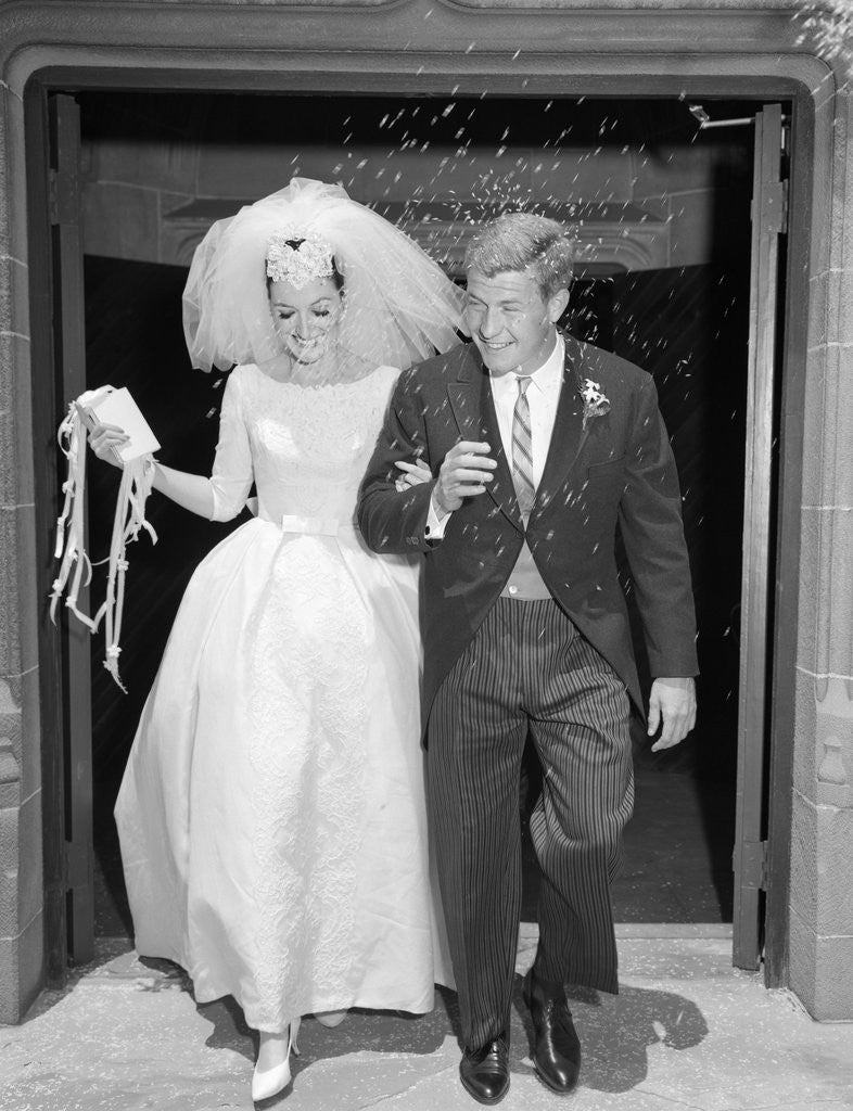 Detail of 1960s Couple Bride And Groom Arm In Arm Leaving Church Under Shower Of Rice by Anonymous
