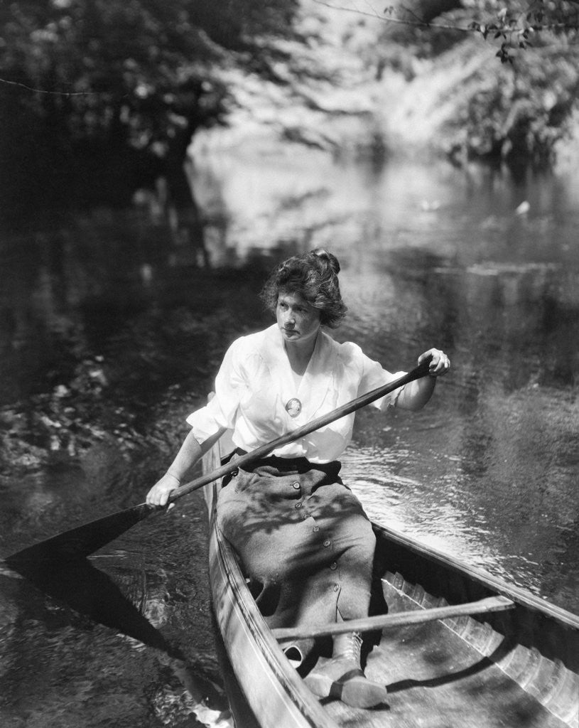 Detail of 1920s Woman With Upswept Hair Paddling Wooden Canoe In Stream by Anonymous