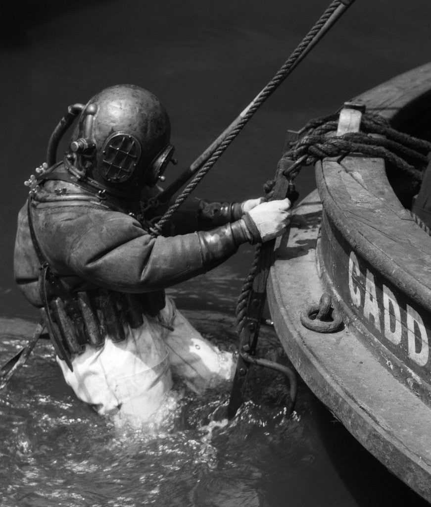 Detail of 1930s Side View Of Diver In Pressure Suit Descending Into Water From Side Of Boat by Anonymous