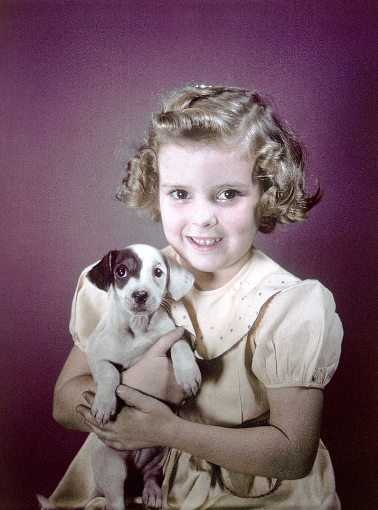 Detail of 1940s 1950s Girl Holding Spotted Puppy by Corbis