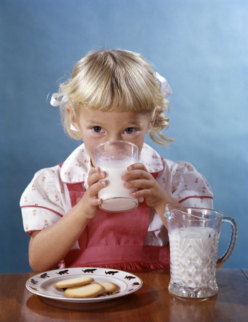 Detail of 1950s 1960s Girl Drinking Milk Plate Cookies by Corbis