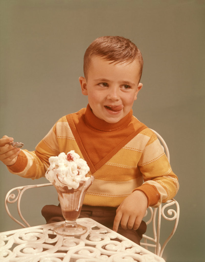 Detail of Boy Sitting At Ice Cream Parlor Table Eating Whipped Cream Cherry Topped Sundae+ by Corbis