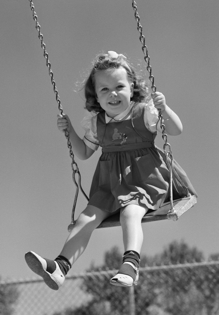 Detail of 1940s Girl Swinging On Playground Swing by Corbis