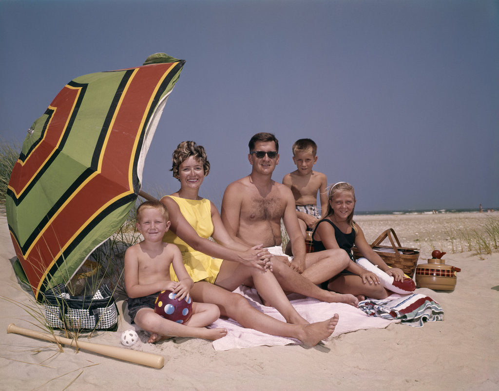 Detail of 1960s Family On Sunny Beach Under Umbrella With Picnic Basket by Corbis