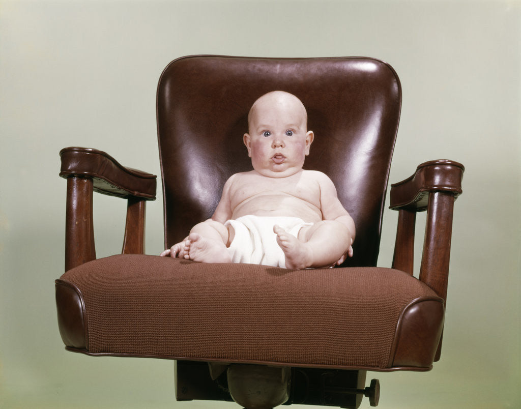 Detail of 1960s Chubby Bald Baby Wearing Cloth Diaper Sitting In Executive Office Business Chair by Anonymous