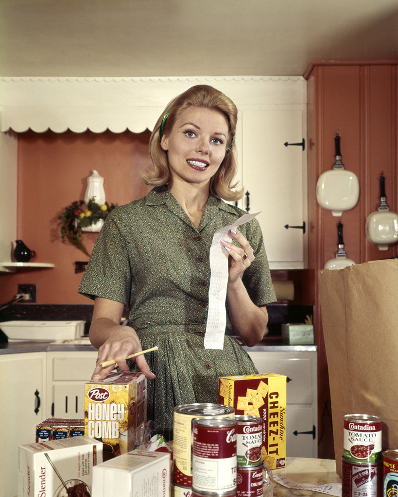 Detail of 1960s Young Housewife While Checking Grocery Shopping Receipt In Kitchen by Anonymous