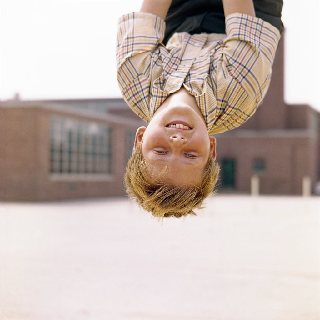 Detail of Red Haired Boy Hanging Upside Down In Elementary School Yard by Anonymous