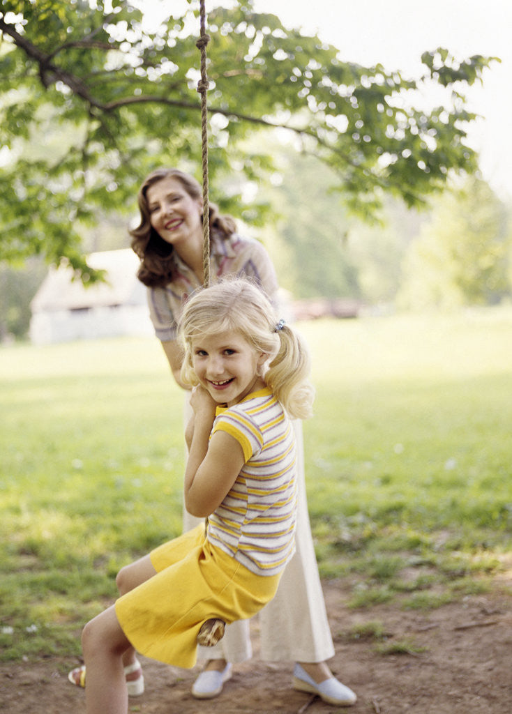 Detail of 1970s Woman Mother With Girl Daughter Swinging Playing On Rope Swing by Anonymous