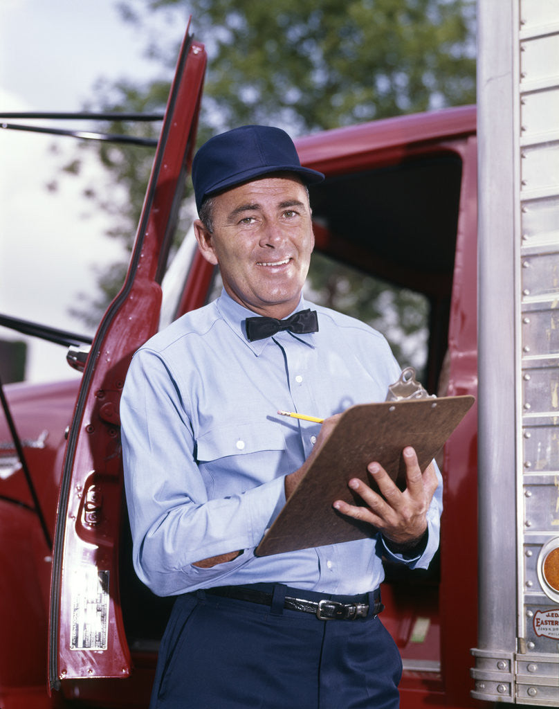 Detail of 1950s 1960s Repairman In Uniform Holding Clipboard Standing In Open Door Of Truck Cab by Anonymous