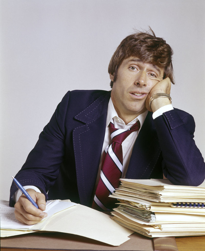 Detail of 1970s Business Man Exhausted Expression Hand To Face Leaning On Pile Paperwork by Anonymous