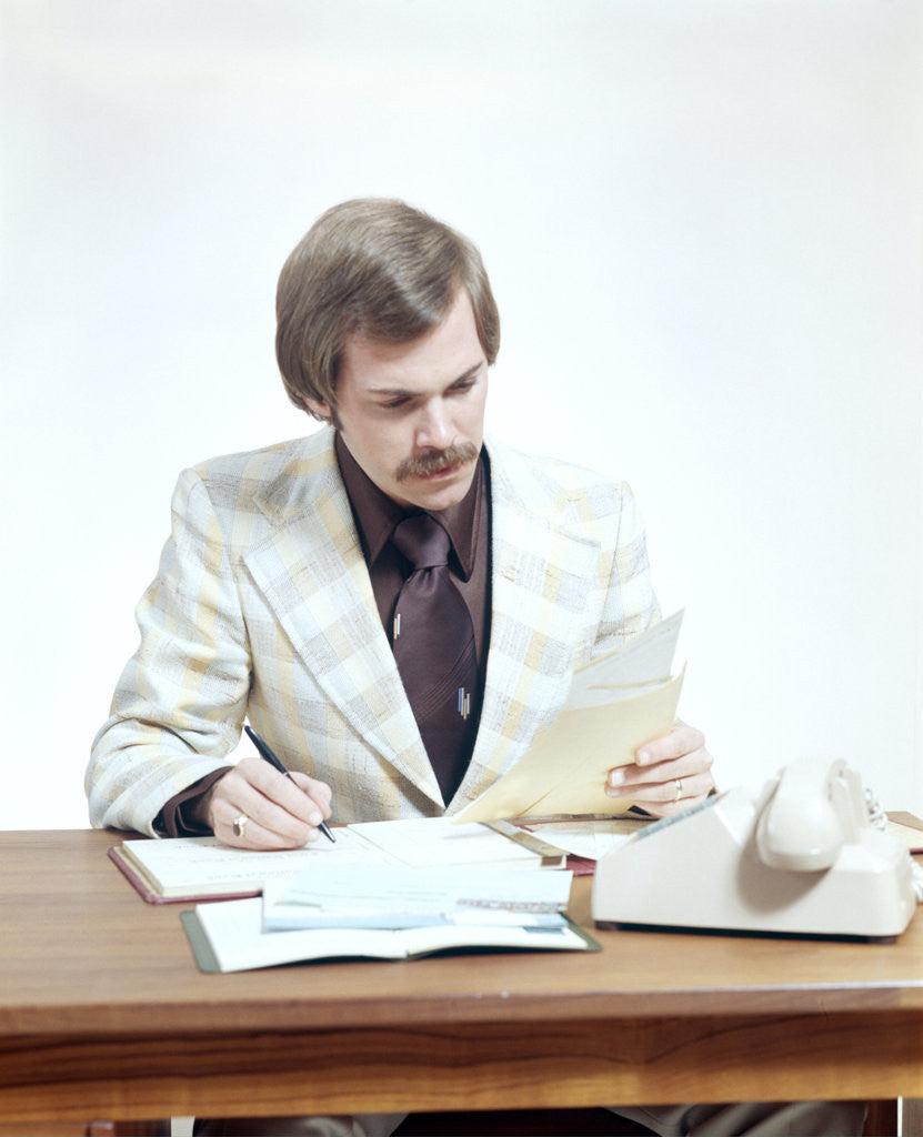 Detail of 1970s Business Man At Desk Handling Paperwork Office Telephone by Corbis
