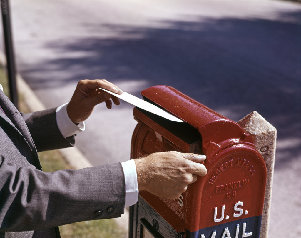 Detail of 1960s Male Hand Dropping Letter Into U.S. Postal Mailbox Man Mailing Letter by Corbis
