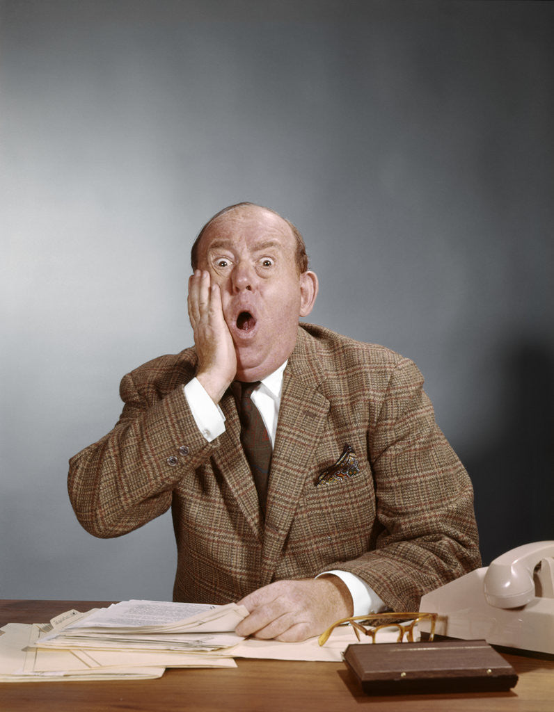 Detail of 1960s Shocked Balding Executive With Hand To Cheek Sitting At Desk by Anonymous