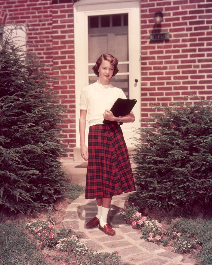 Detail of 1950s Teenage Girl Holding School Books Walking Down Flagstone Walk by Anonymous