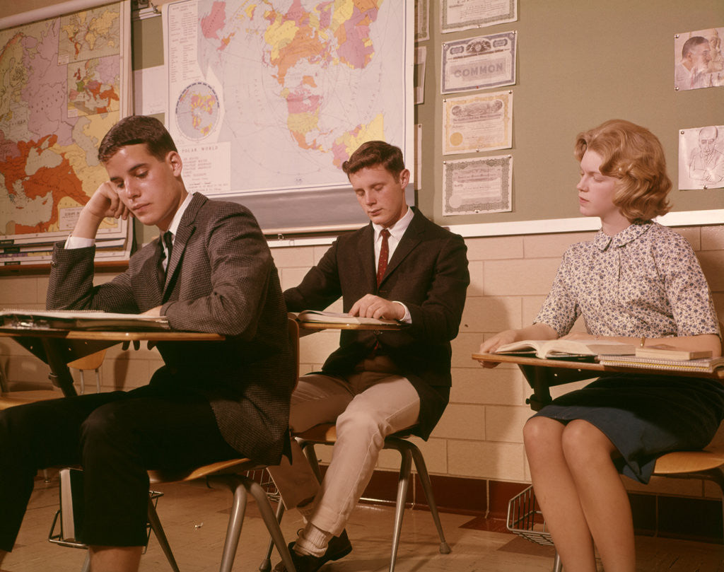 Detail of 1960s 3 College High School Students Sitting Desk Chairs Reading Studying Classroom by Anonymous