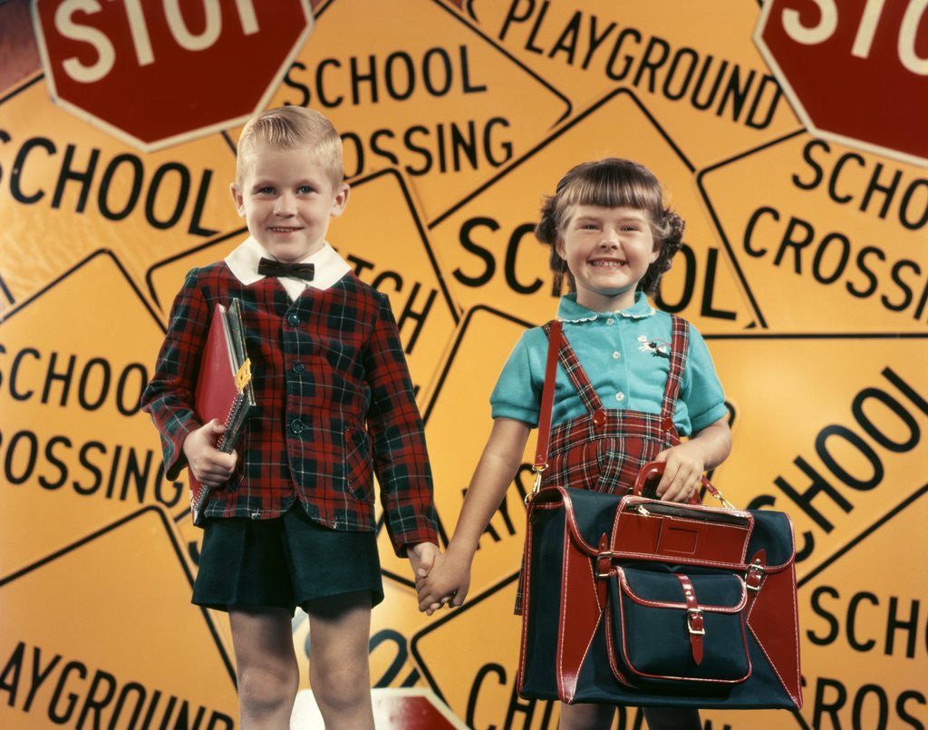 Detail of 1950s Girl And Boy With Book Bag And Books Holding Hands Together In Front Of School by Corbis