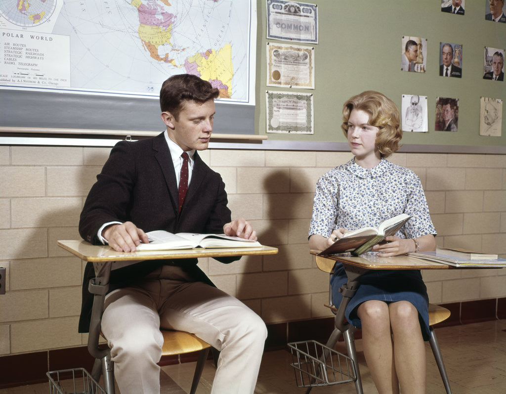 Detail of 1960s Teenage Boy Girl Seated Classroom Desks Talking by Anonymous