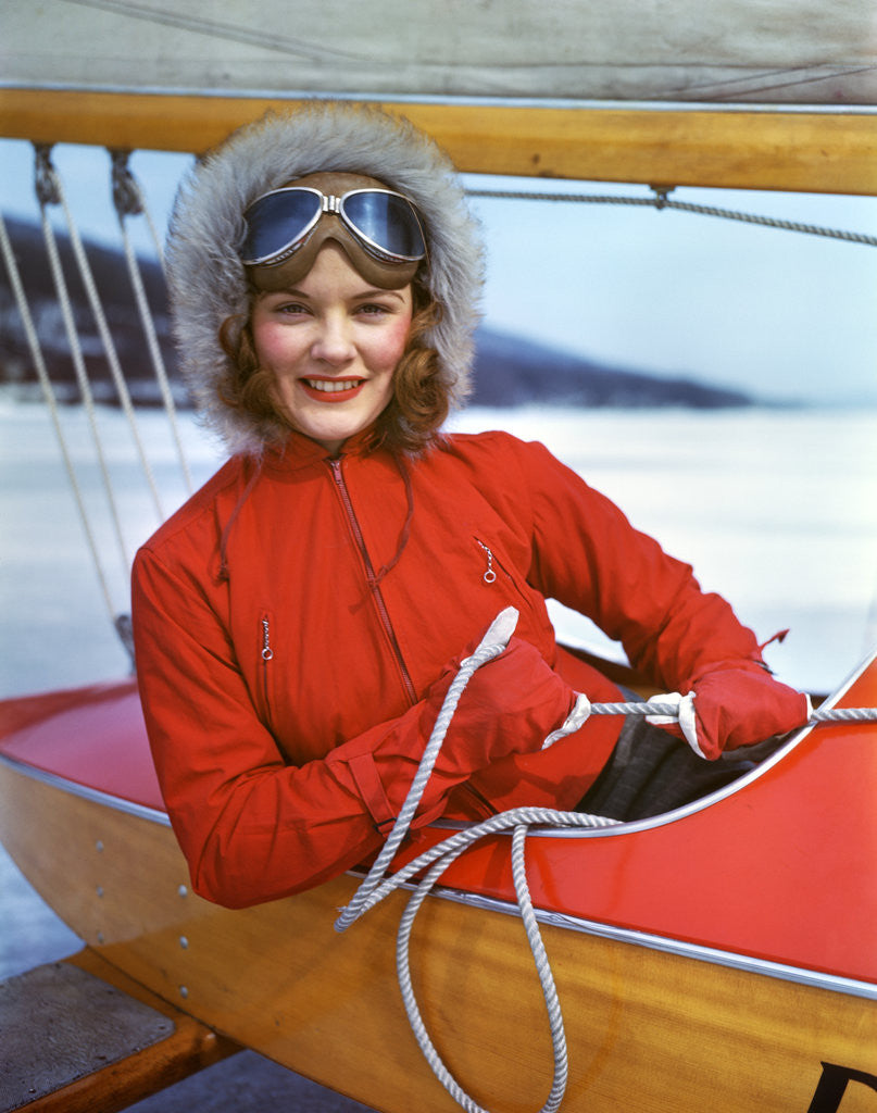 Detail of 1940s Young Woman Sitting In Cockpit Of Ice Boat Holding Sheet Rope To Sail Boom by Corbis