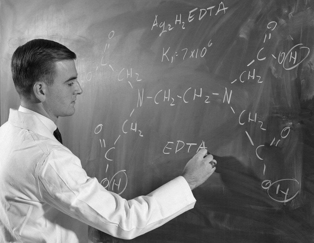Detail of 1960s Profile Of Scientist Man In Lab Coat Writing Out Chemical Formula On Blackboard by Anonymous