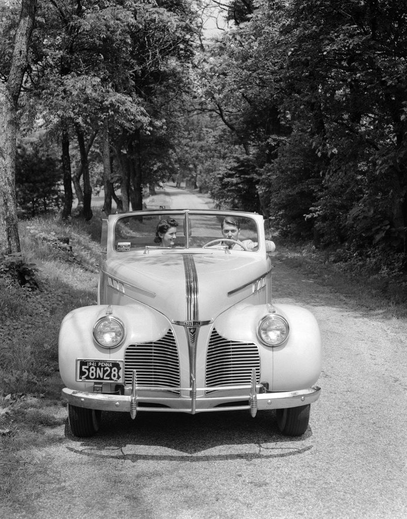 Detail of 1940s 1941 Couple Man And Woman In Pontiac Convertible Driving On Country Lane In Countryside by Anonymous