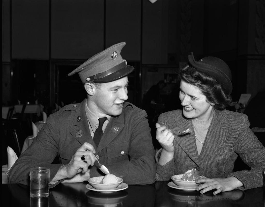 Detail of 1940s Soldier In Army Uniform And Girlfriend Sitting At Soda Fountain Counter Eating Dish Of Ice Cream by Anonymous
