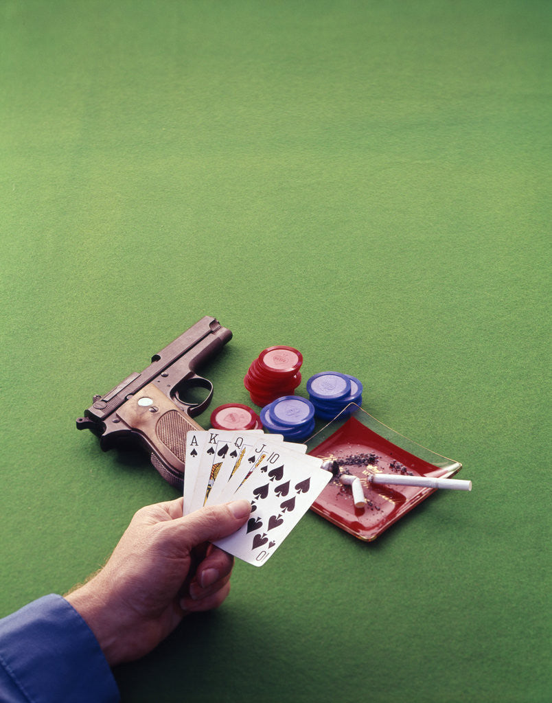 Detail of 1970s Man Holding Royal Straight Flush In Spades Playing Cards with Semi-Automatic Pistol by Corbis