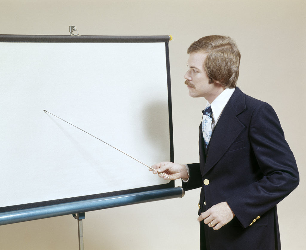 Detail of 1970s Business Man Giving Presentation Pointing At Projection Screen by Anonymous