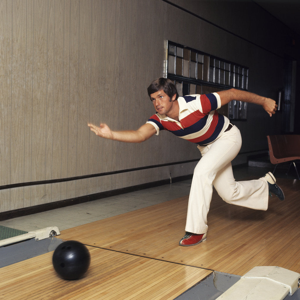Detail of 1970s Man Stripe Shirt Flare Leg Pants Throwing Bowling Ball Down Lane Alley by Anonymous