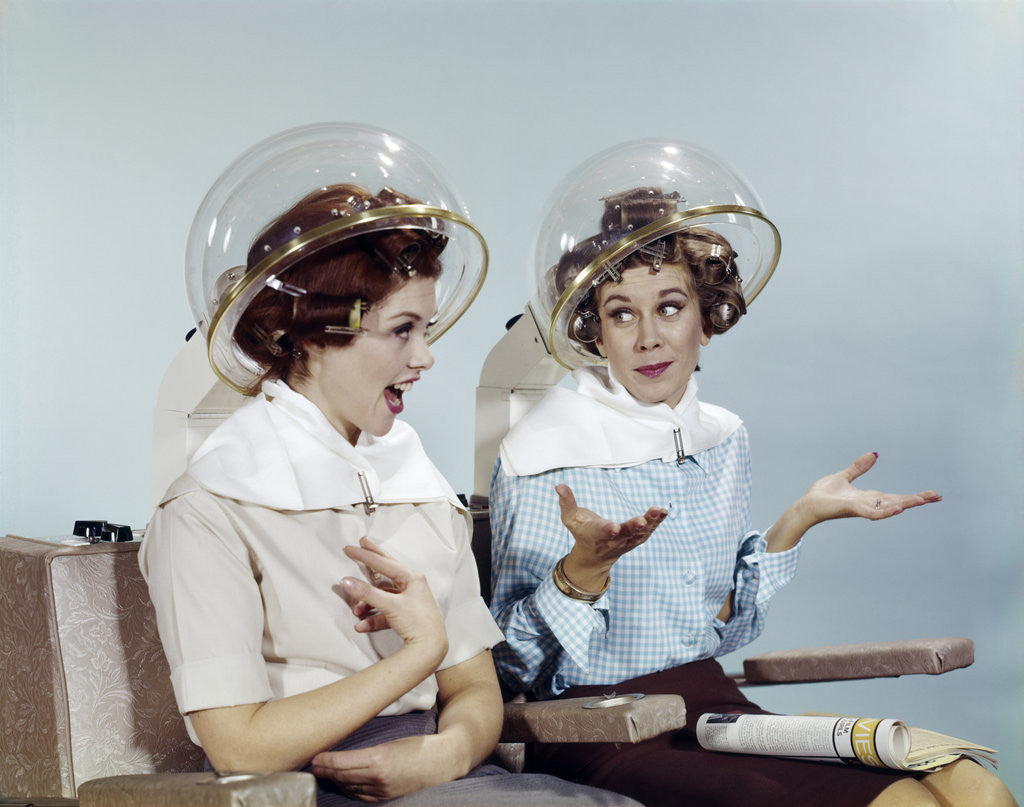 Detail of 1960s 2 Women Sit Under Beauty Salon Hair Dryers Clear Helmets Hoods Curlers Talking Gossip by Anonymous