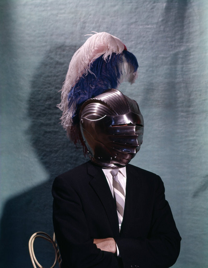 Detail of 1960s Businessman Wearing 16th Century Medieval Helmet With Visor Closed Blue White Feather by Corbis