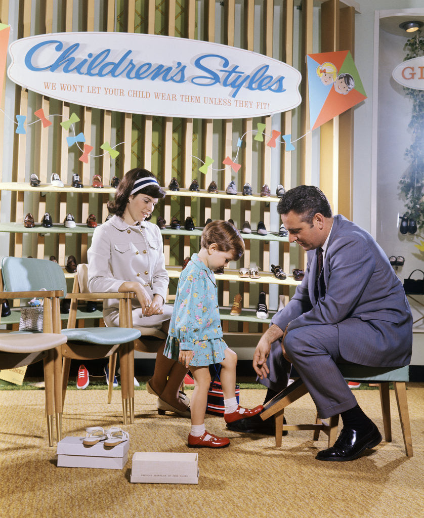 Detail of 1960s 1970s Mother Watching Salesman Fit Shoes On Daughter In Shoe Section Of Department Store by Anonymous